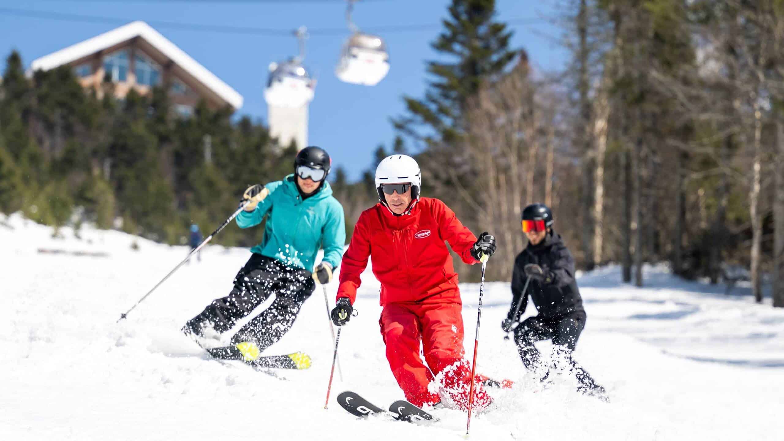 Skieurs en action au printemps à Tremblant avec vue sur la station.