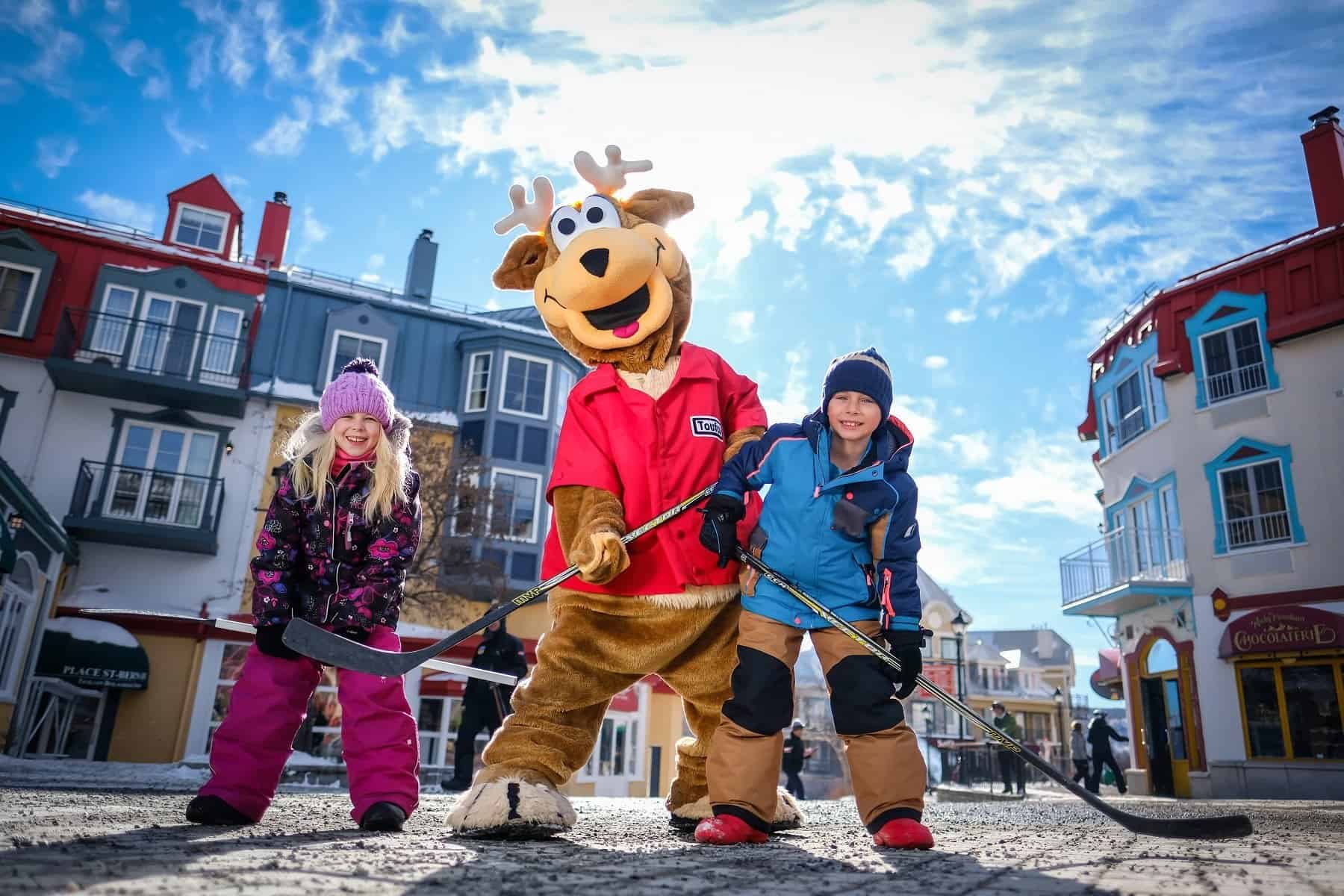 Enfants et mascotte de renne en plein air à Tremblant.
