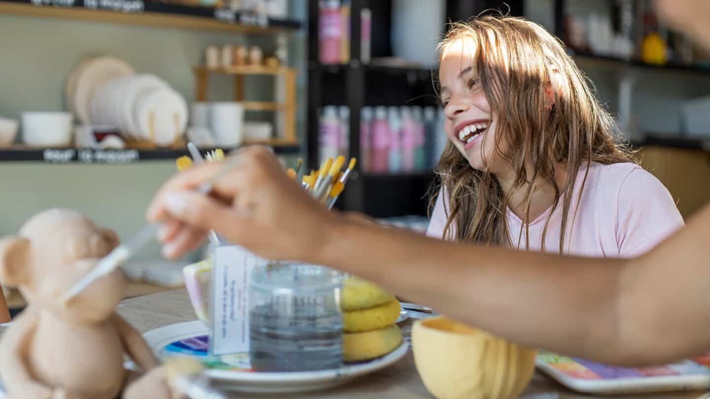 Jeune femme souriante et détendue, dégustant un dessert dans un café de Tremblant.