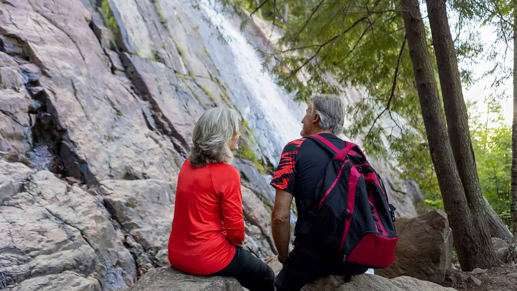 Couple enjoying nature and waterfall at Tremblant on a warm summer day.