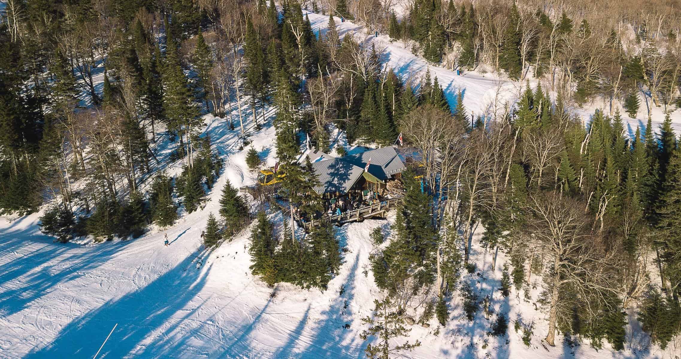 Refuge du Trappeur entouré d’arbres enneigés sur le Versant Soleil.