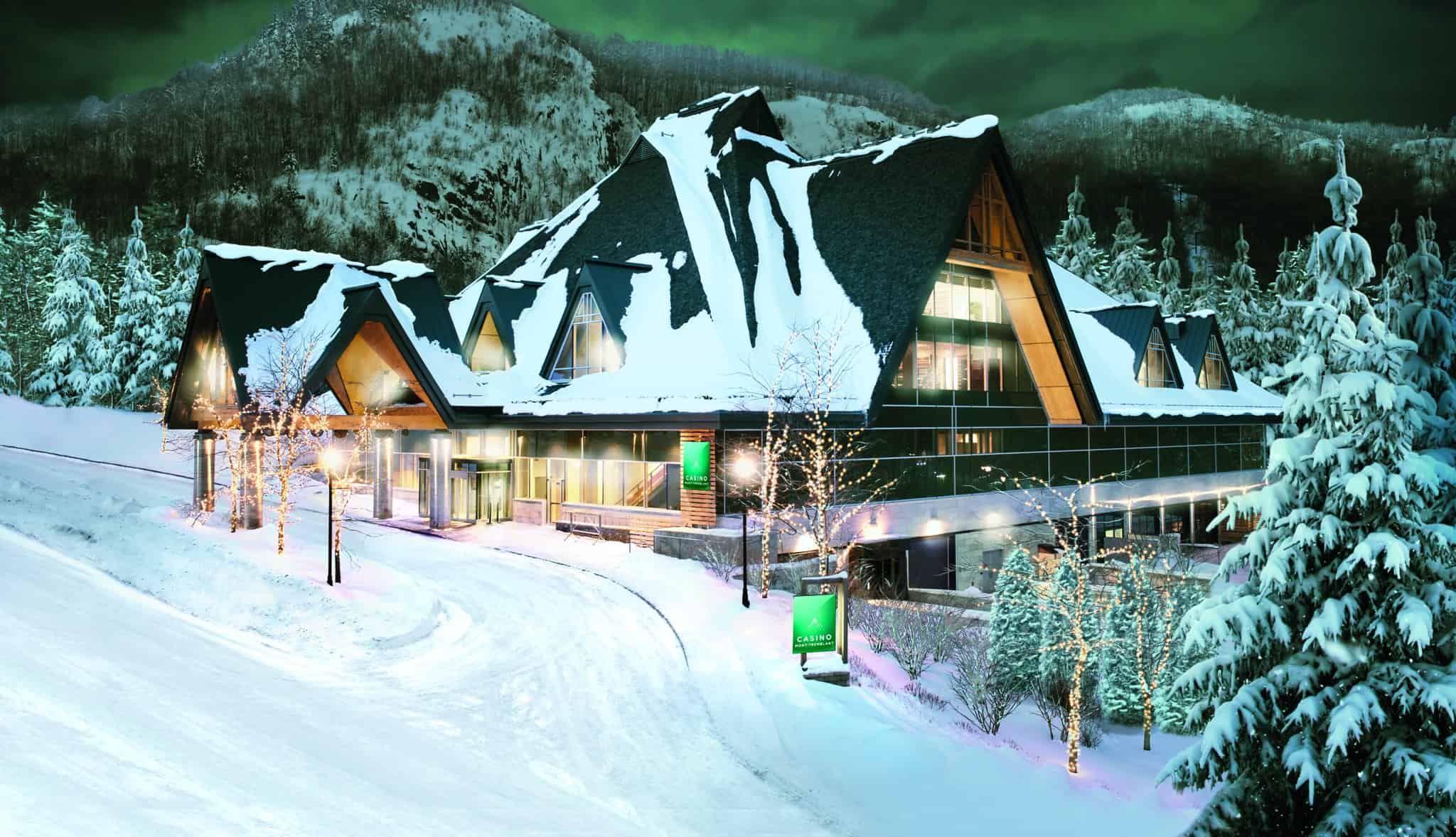 Hôtel Tremblant sous la neige avec montagnes en arrière-plan.