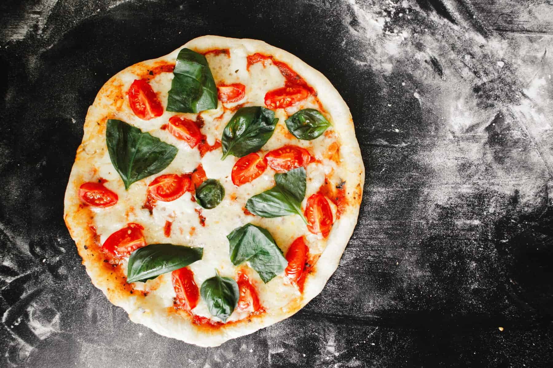 Pizza Margherita fraîche avec basilic frais sur une pâte dorée.