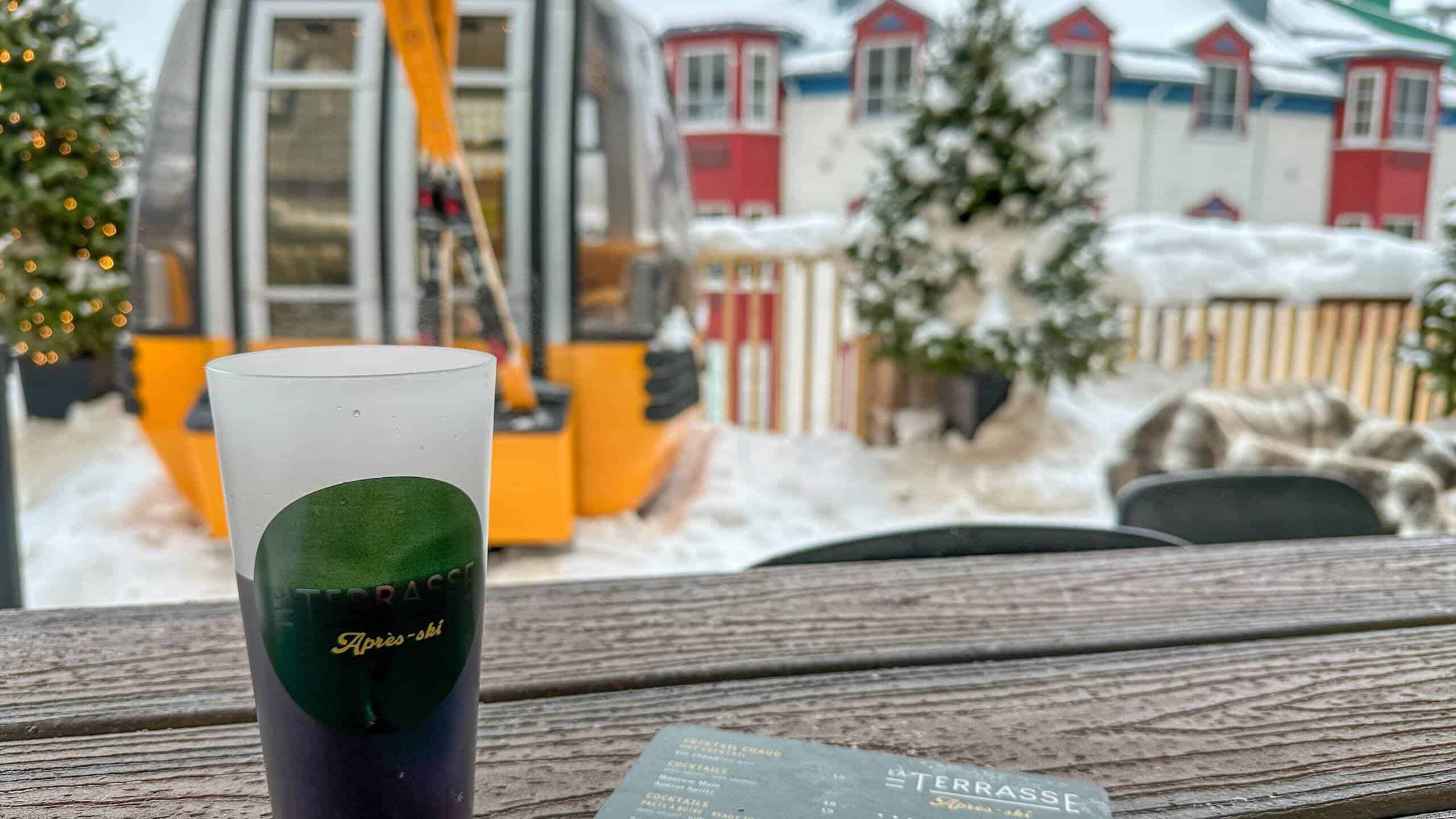 Verre de cocktail signature avec vue sur Tremblant en arrière-plan.
