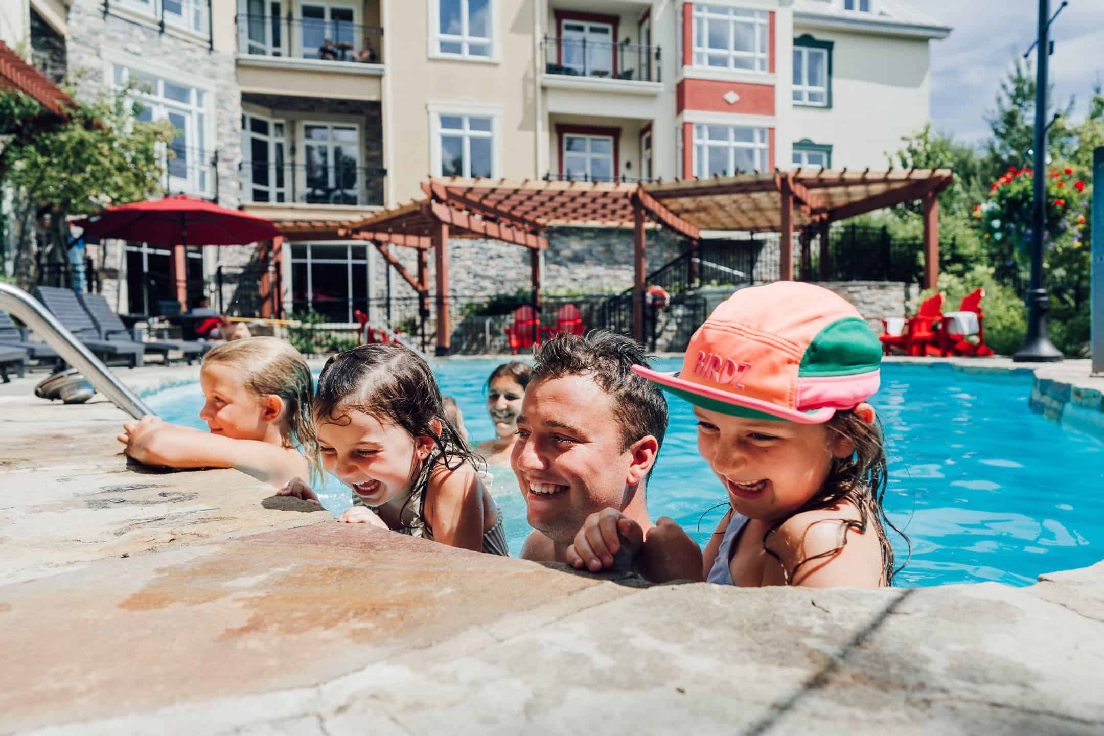 Famille profitant d'une piscine à Tremblant en été.