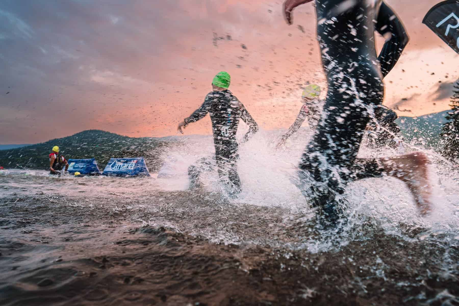 Triathlètes entrant dans l'eau lors de l'Ironman Mont-Tremblant, départ en mer agitée.
