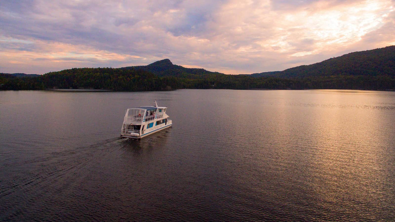 Bateau naviguant sur le lac Tremblant au coucher du soleil.