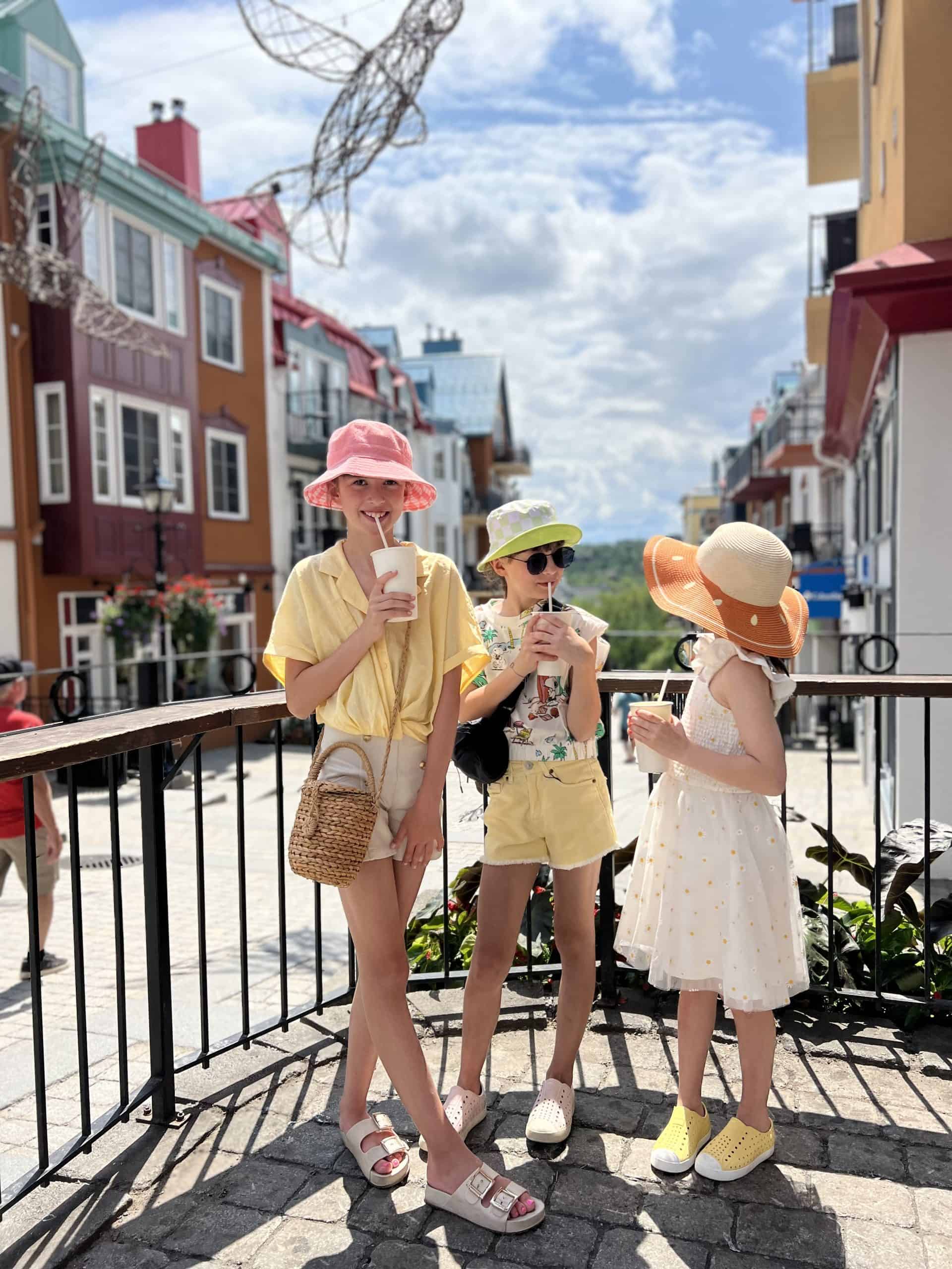 Trois enfants avec des glaces dans une rue colorée de Tremblant.