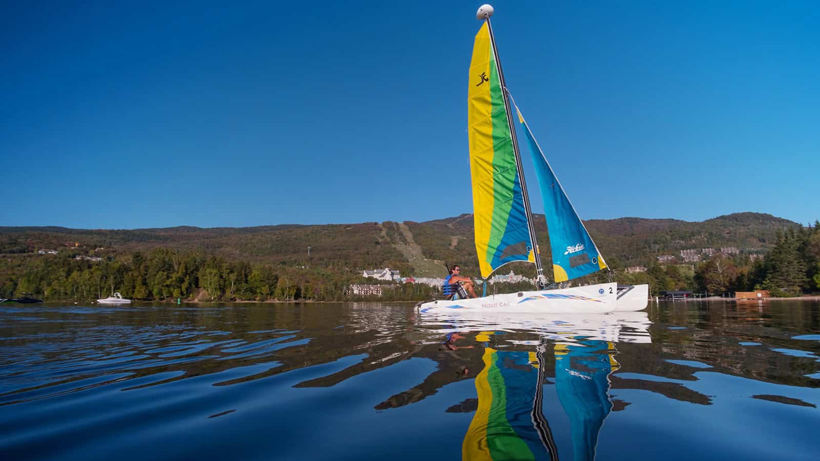 Voile colorée sur le lac Tremblant par une journée ensoleillée.
