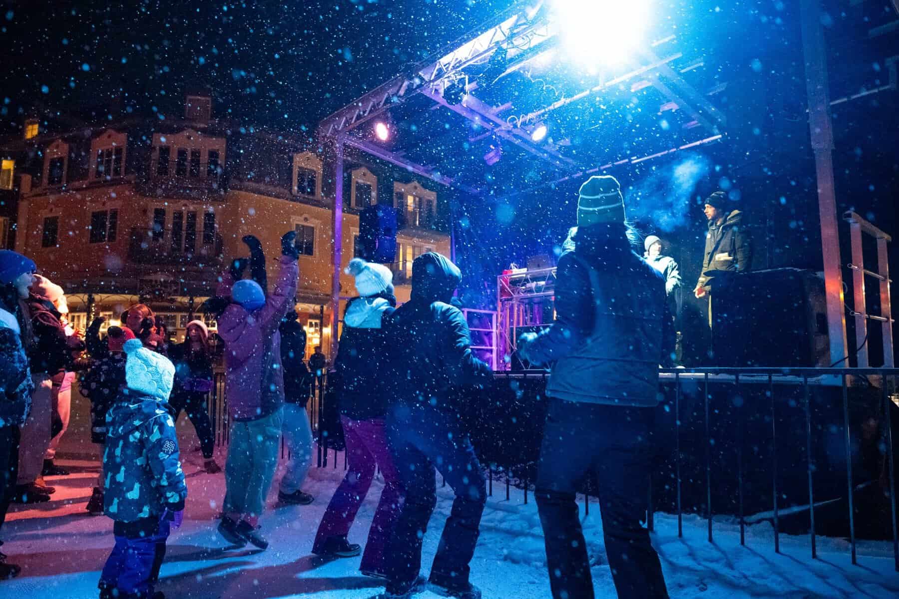 Groupe de personnes dansant devant scène en soirée hivernale Tremblant.