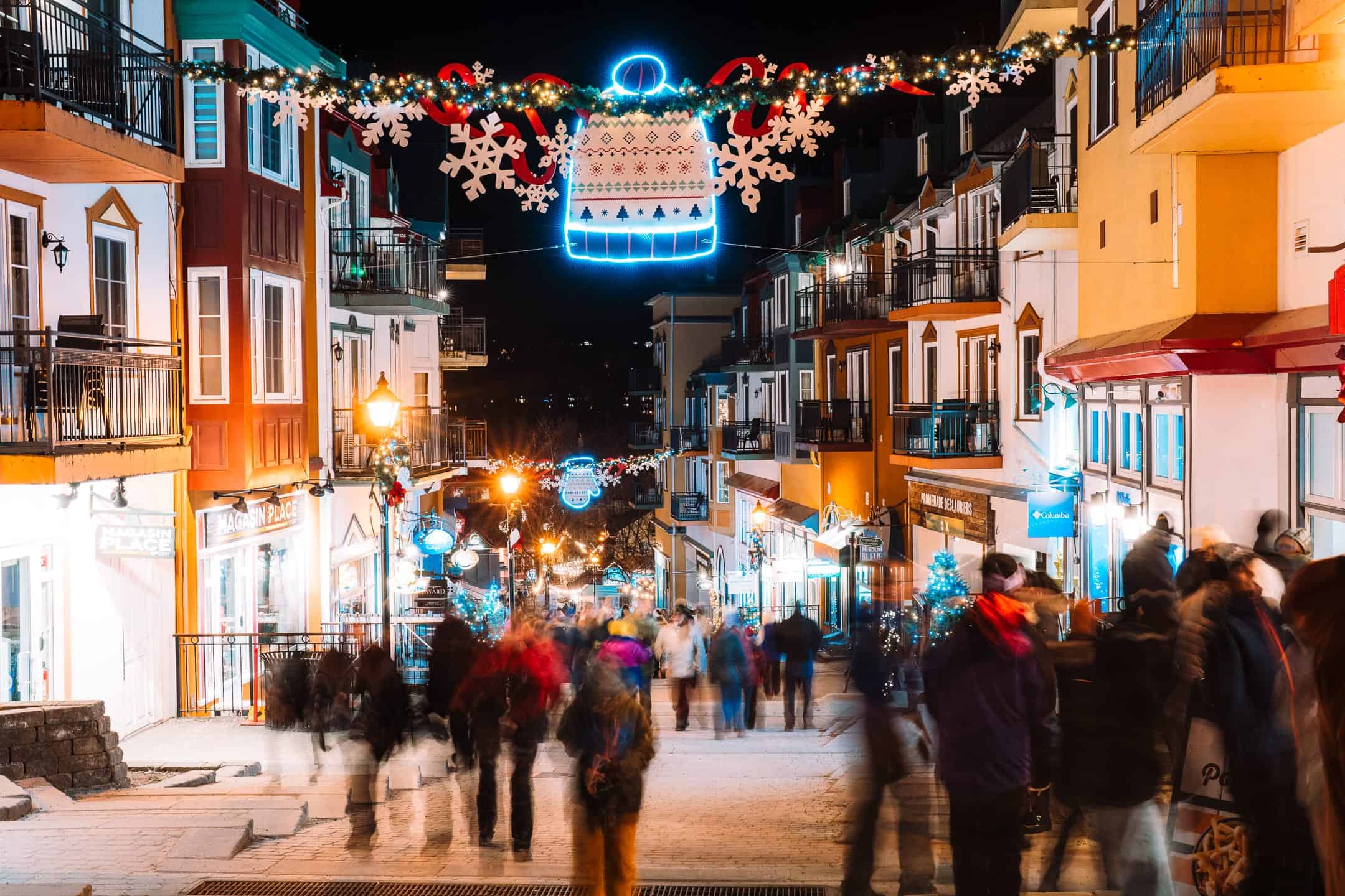 Fête de Noël à Tremblant avec décorations lumineuses et foule festive.