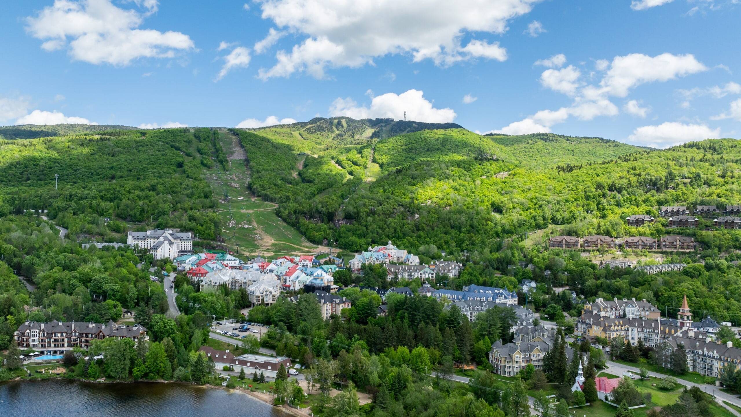 Scenic view of Tremblant Pedestrian Village surrounded by lush green mountains.