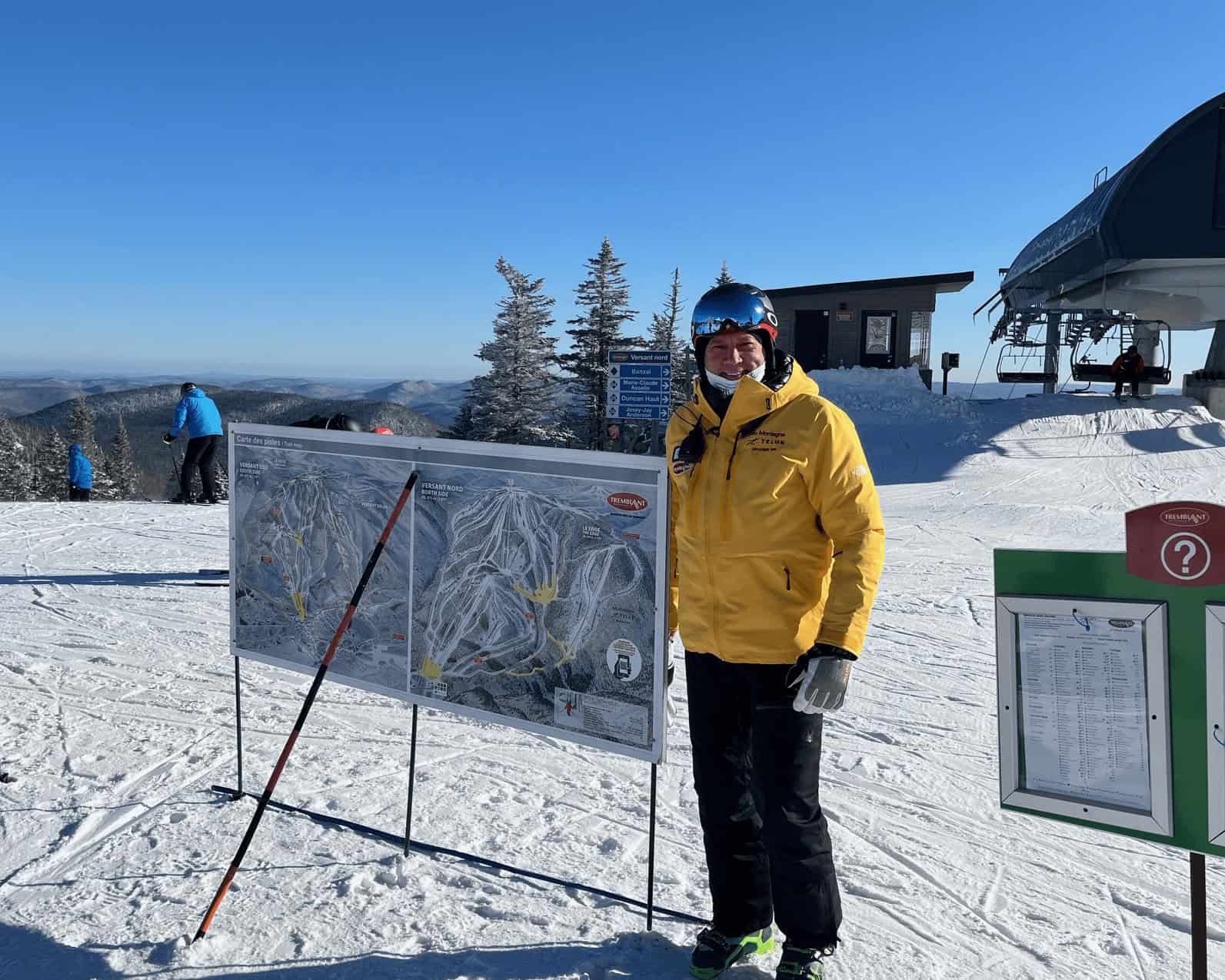 Person in yellow ski jacket with ski map at Mont Tremblant ski resort.