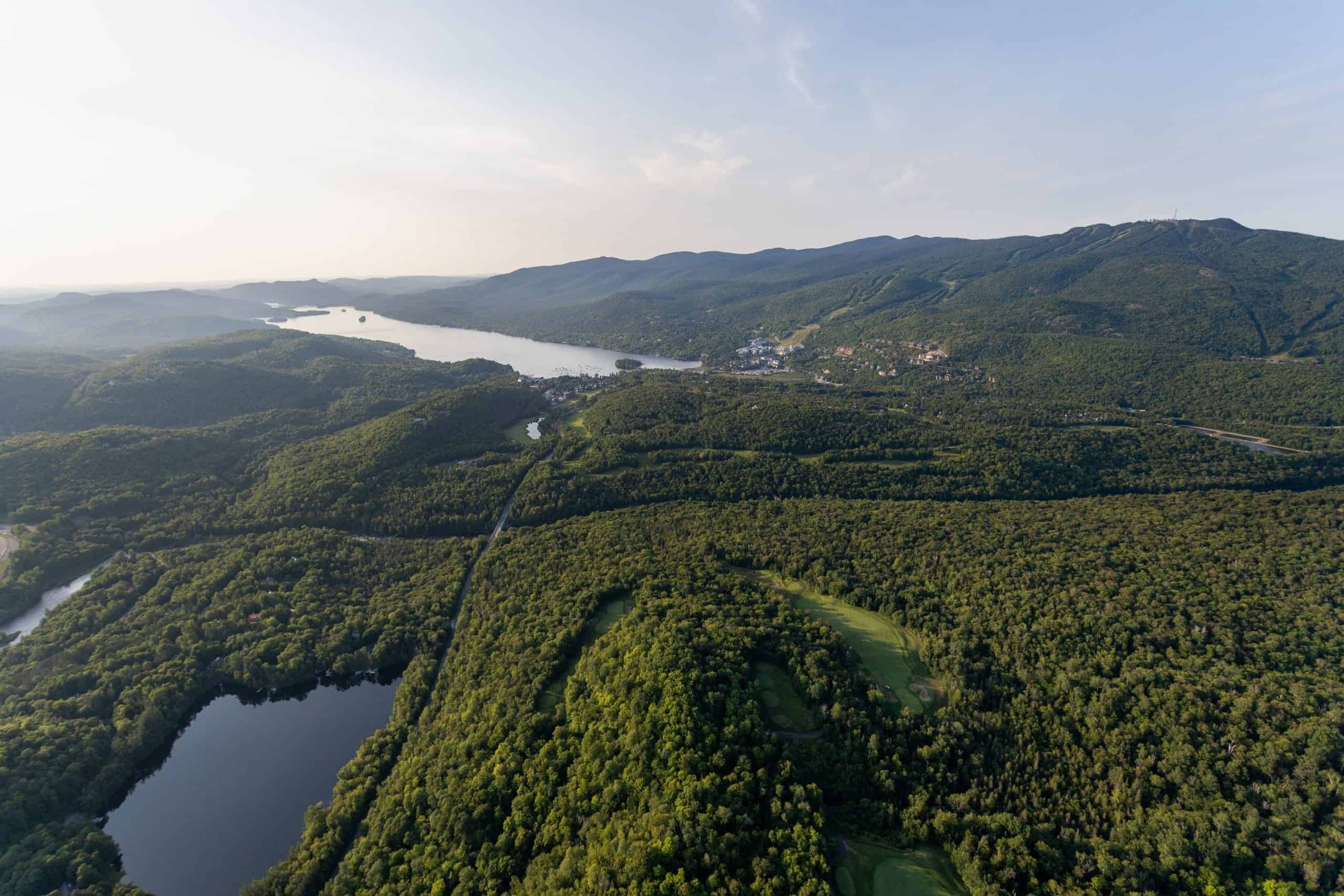 Vue aérienne des paysages de Mont-Tremblant avec forêts et lacs.