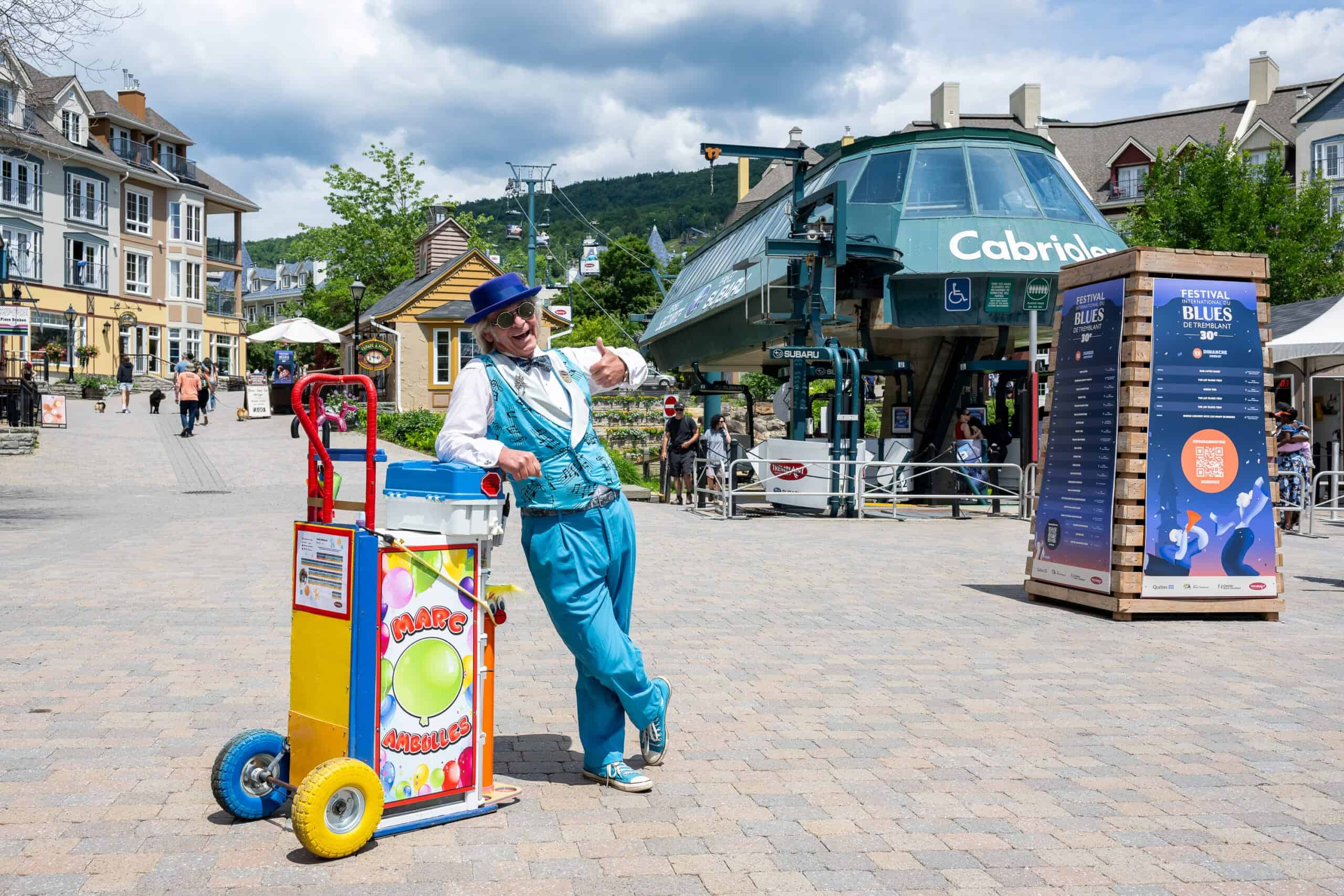 Artiste de rue avec chapeau bleu et costume turquoise dans le village de Tremblant.