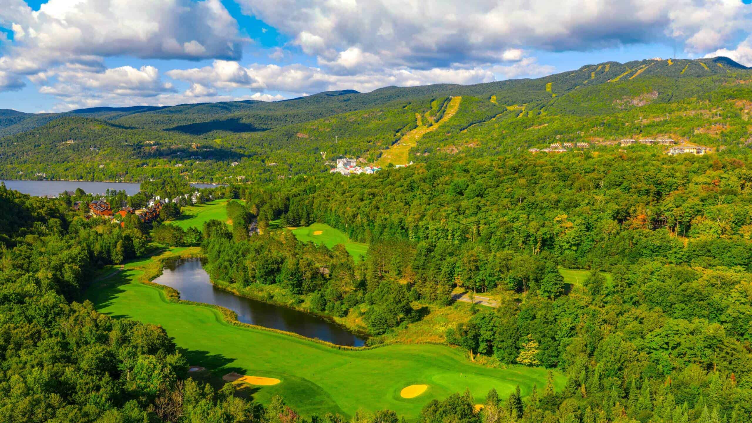 Scenic view of Tremblant golf course with lush greenery and mountains.