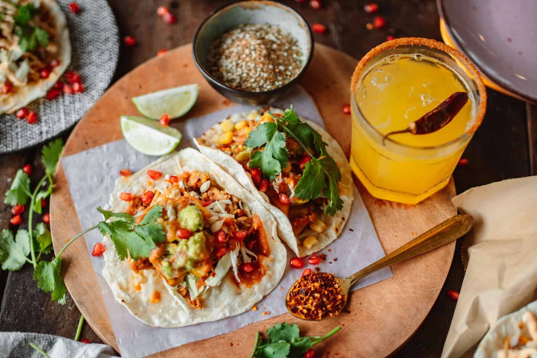 Tacos mexicains garnis de salsa et guacamole, assiette colorée dans un cadre mexicain.