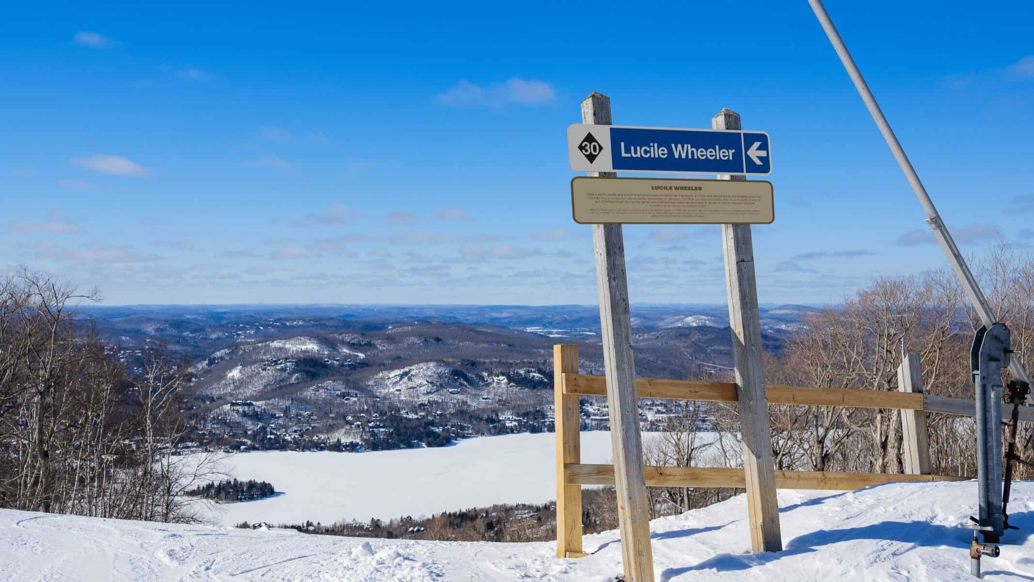 Panneau indiquant Lucile Wheeler sur une piste de ski enneigée.