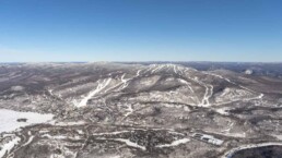 Snow-covered mountain slopes and clear blue sky at Mont-Tremblant hills.