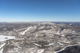 Snow-covered mountain slopes and clear blue sky at Mont-Tremblant hills.