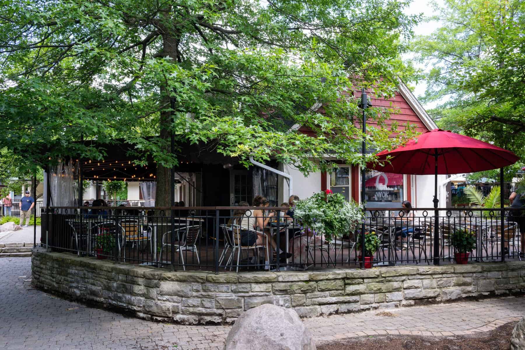 Terrasse en plein air entourée d’arbres près d’un village piétonnier Tremblant.