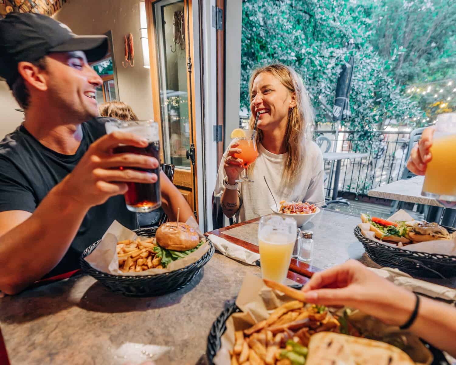 Groupe dégustant burgers et boissons sur une terrasse en Tremblant.