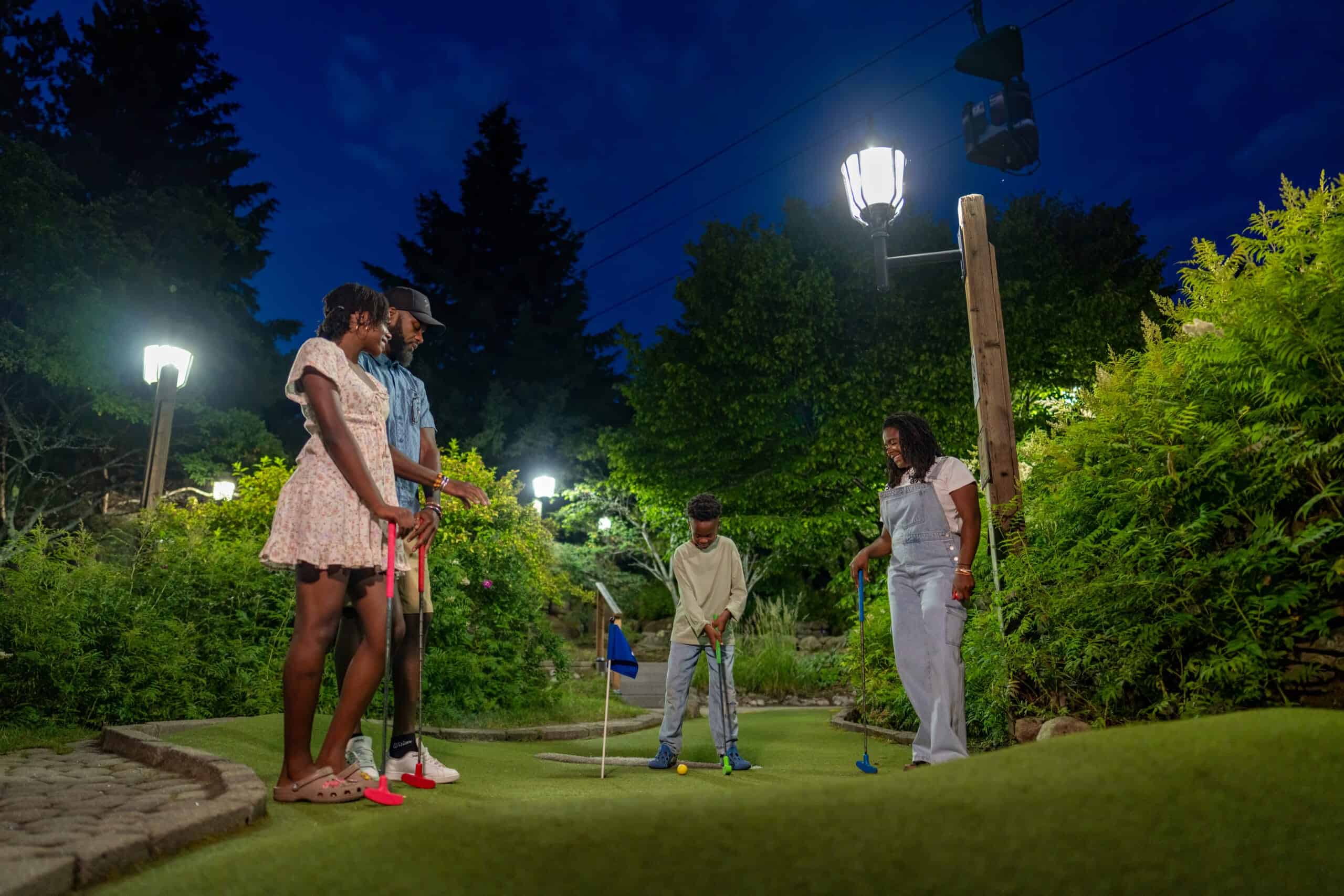 Groupe de personnes jouant au mini-golf en soirée à Tremblant.
