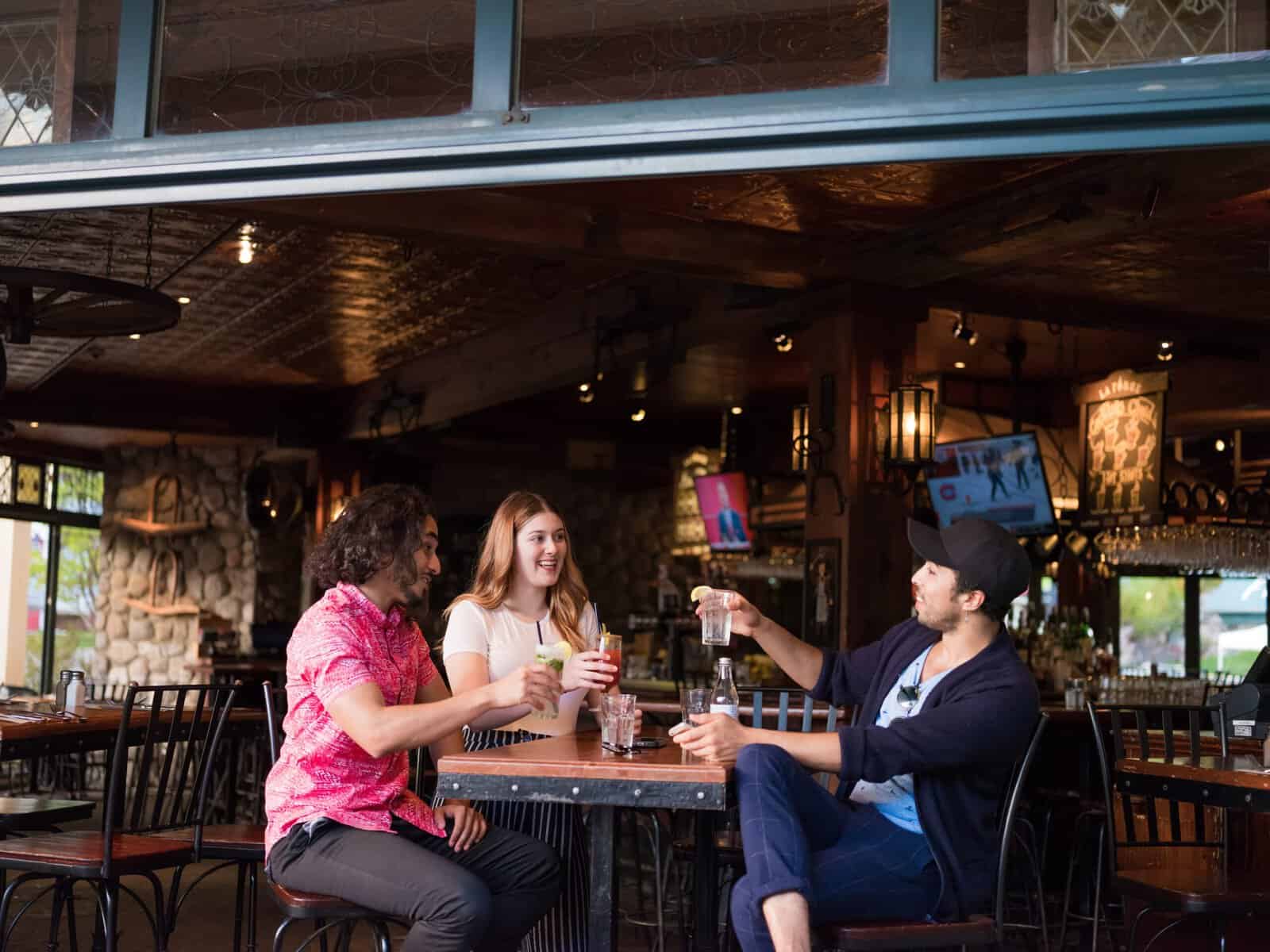 Groupes de amis trinquant autour d'une table au bar de Tremblant.