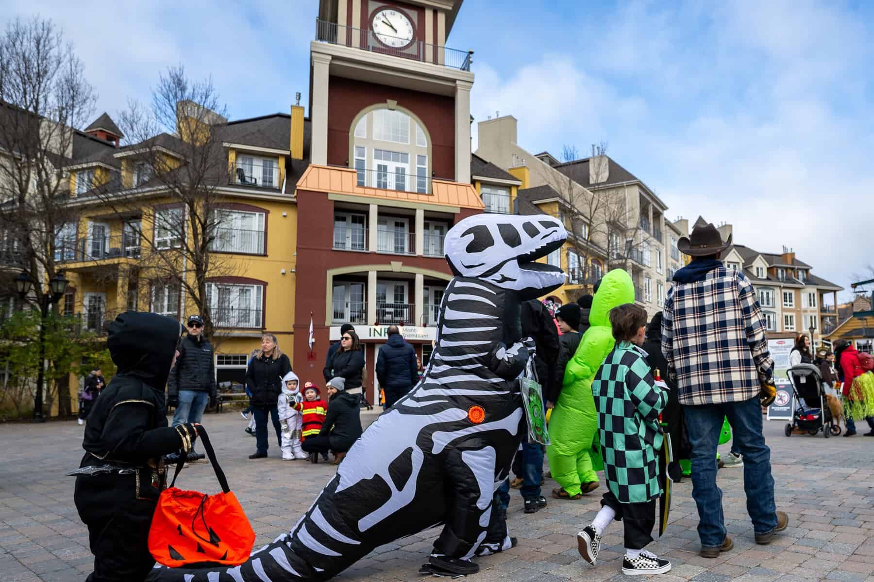 Personnes en costumes d’Halloween dans une place pittoresque de Tremblant.